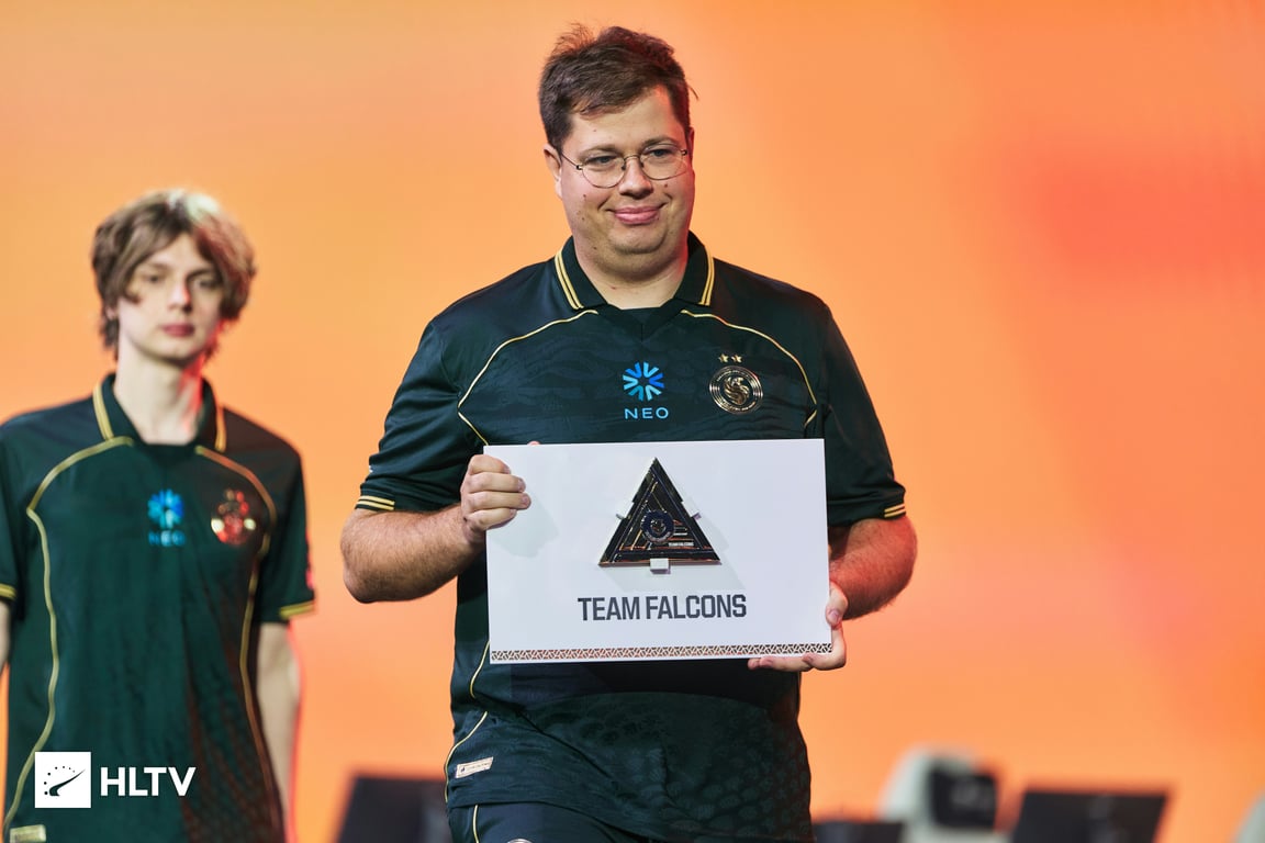 karrigan holding a card with Team Falcons written on it for EWC